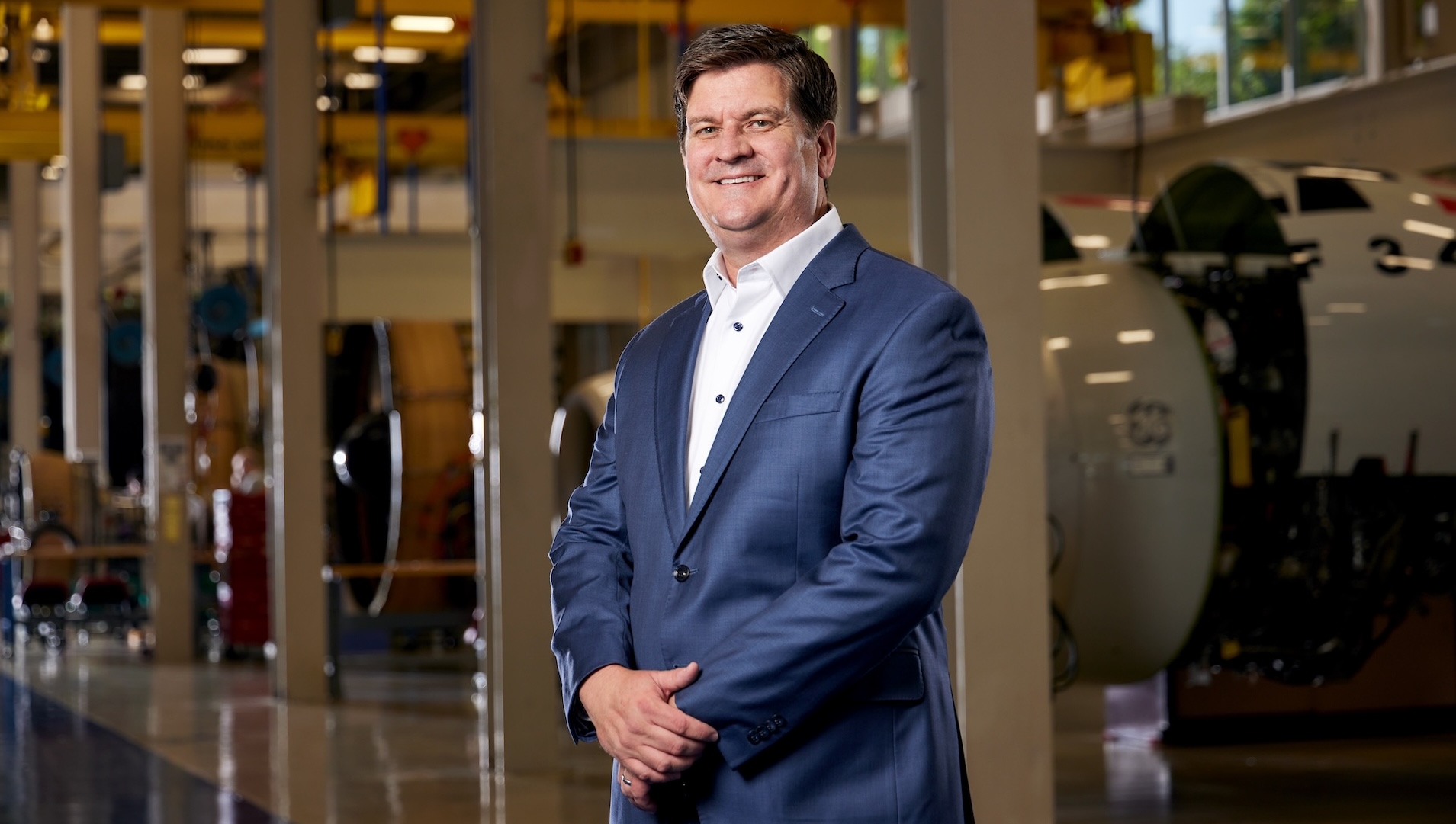 Phil Wickler standing in a GE Aerospace engine maintenance facility