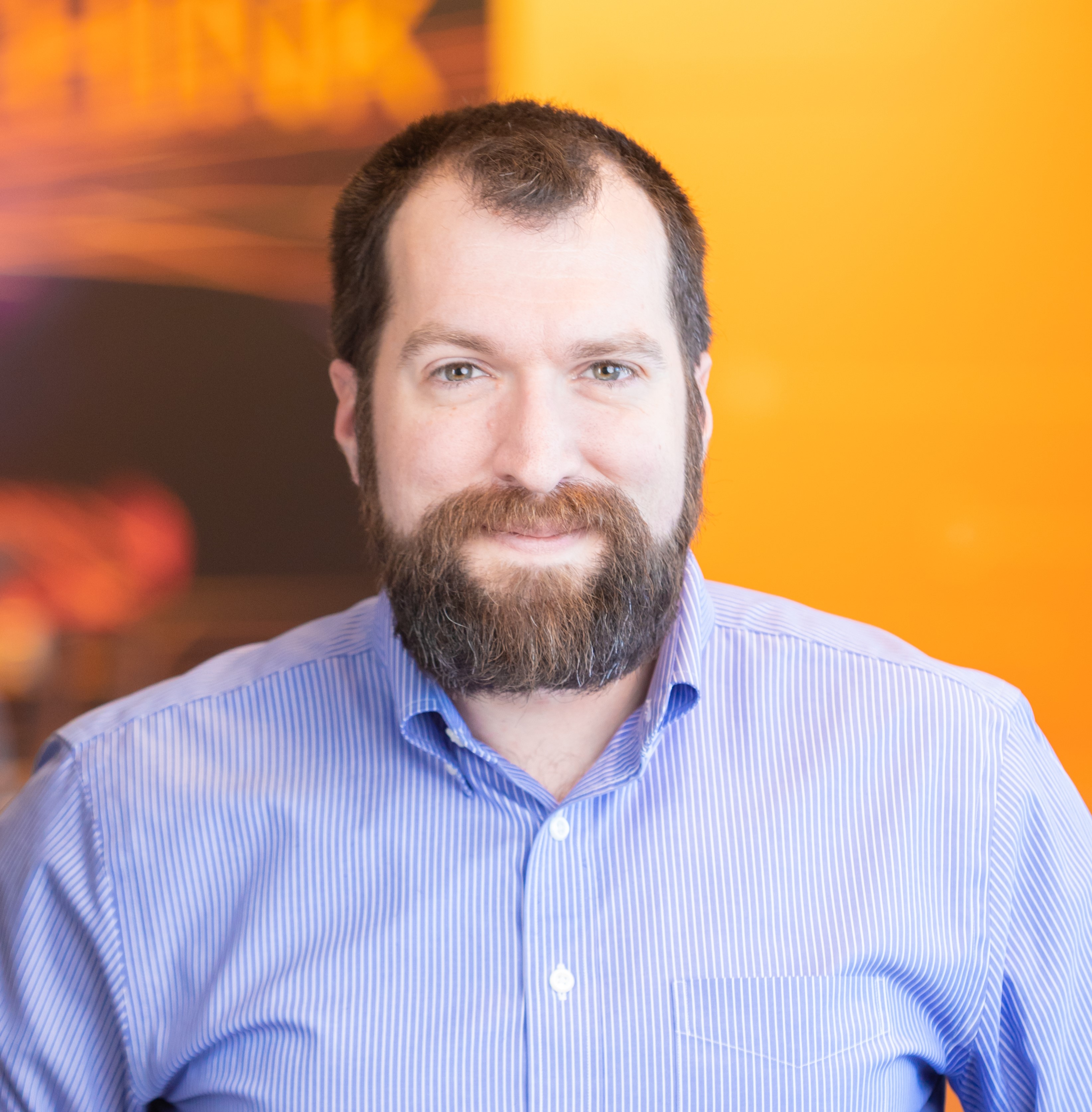 Paul Ardis headshot on yellow-orange background