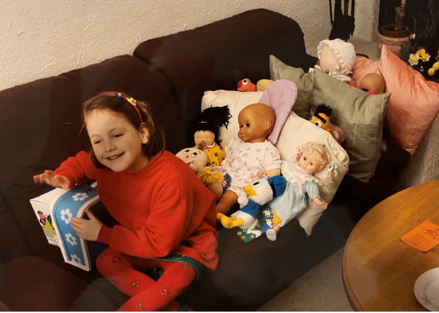 Young girl sitting on a couch with dolls