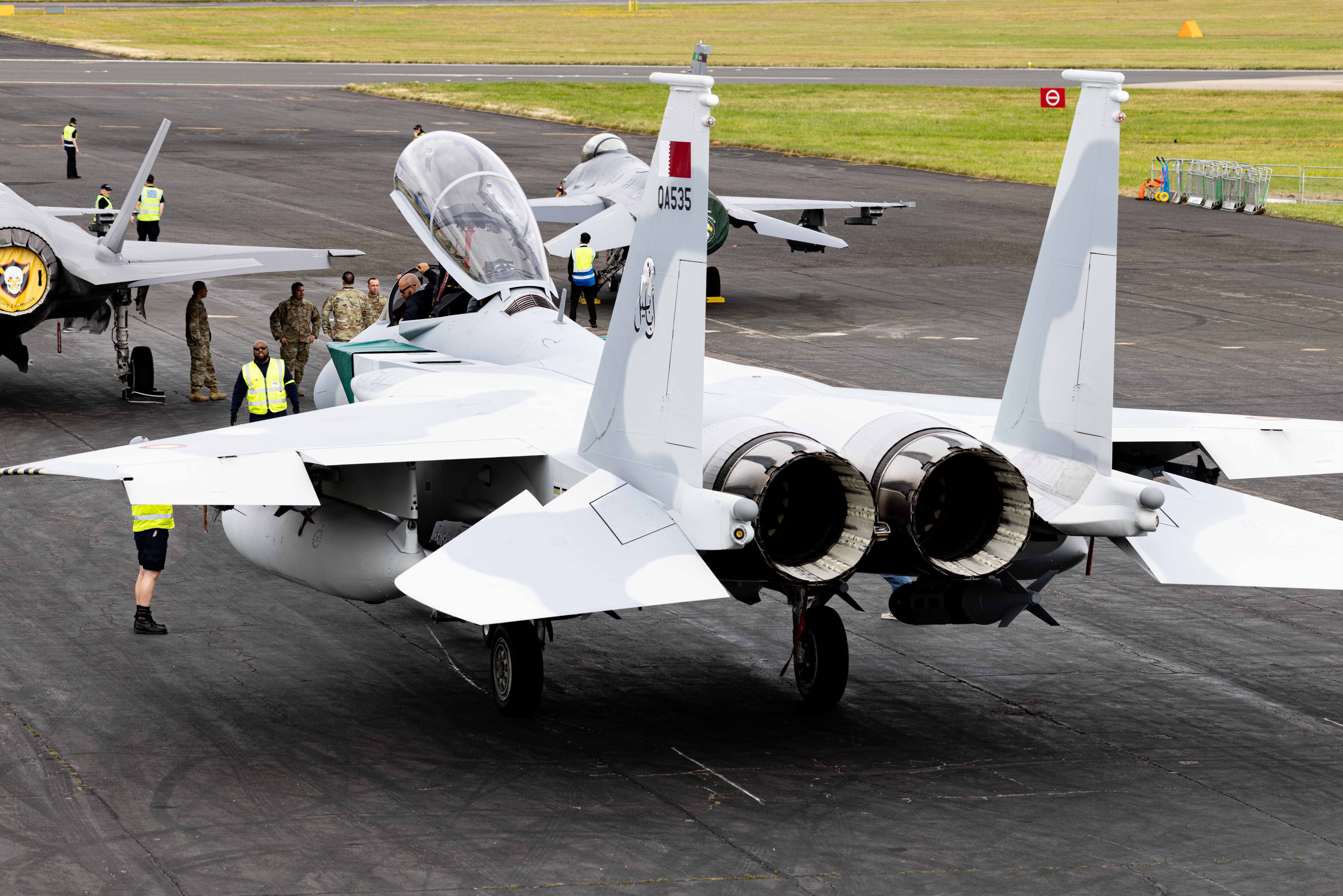 F-15 jet on a tarmac with members of the U.S. military