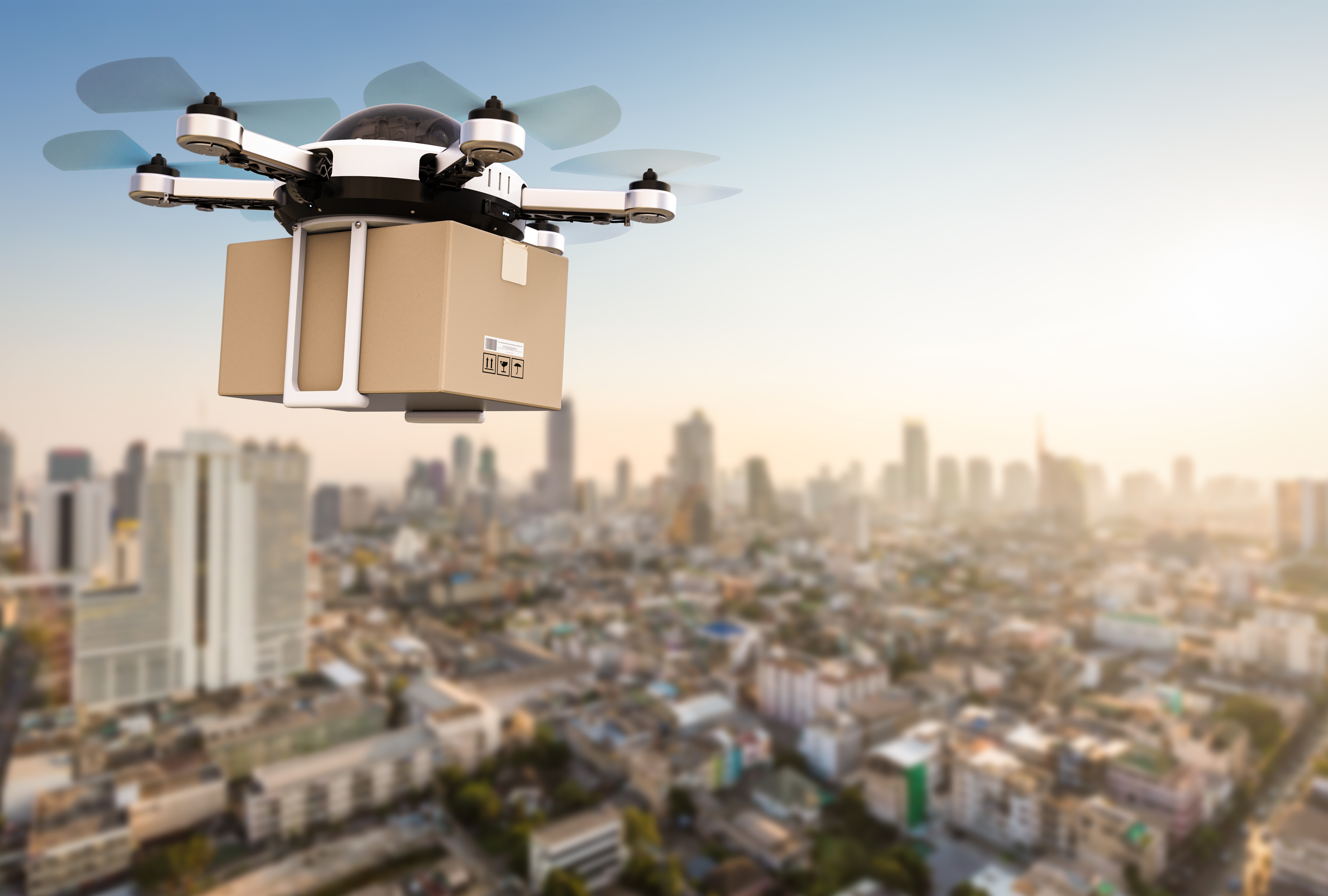 Drone crying a package above a city.