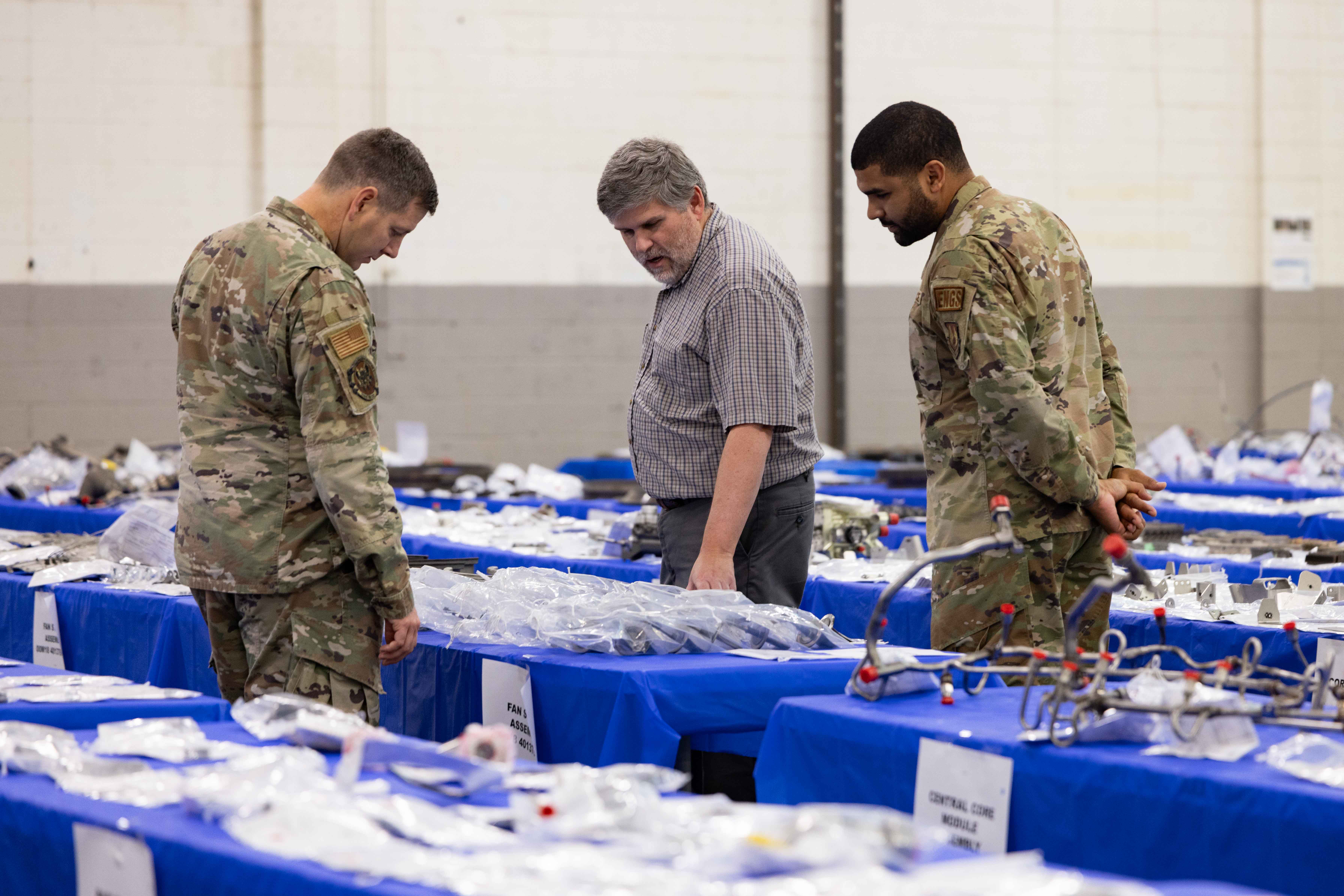 GE Aerospace engineer and two USAF representatives inspect disassembled XA100 test parts