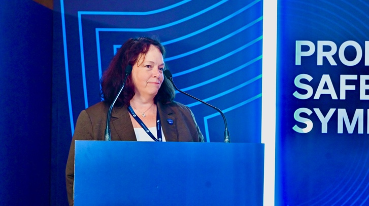 Terri Braun Voutsas standing at a blue podium