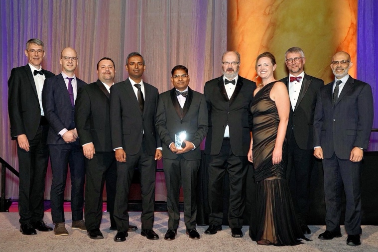 Nicole Tibbetts standing with a group of men in black tie