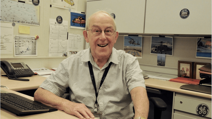 Tony Rosa smiling, sitting at his desk