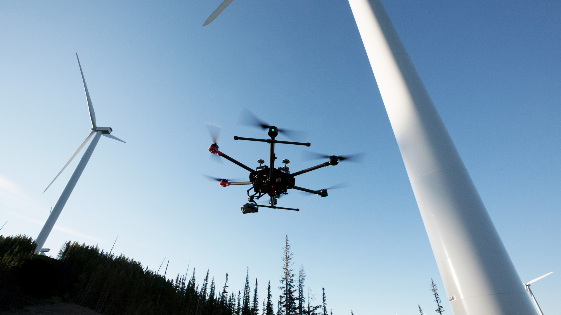 drone flying between windmills 